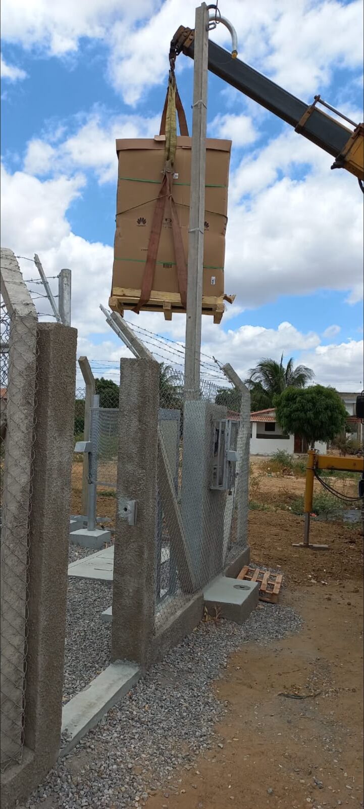 Caminhão munck içando carga paletizada com cintas de elevação